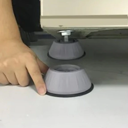hand placing ShakeProof Pad under washing machine
